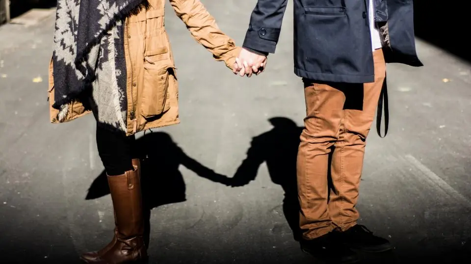 Sexdating for par: et par går hånd i hånd med lange skygger